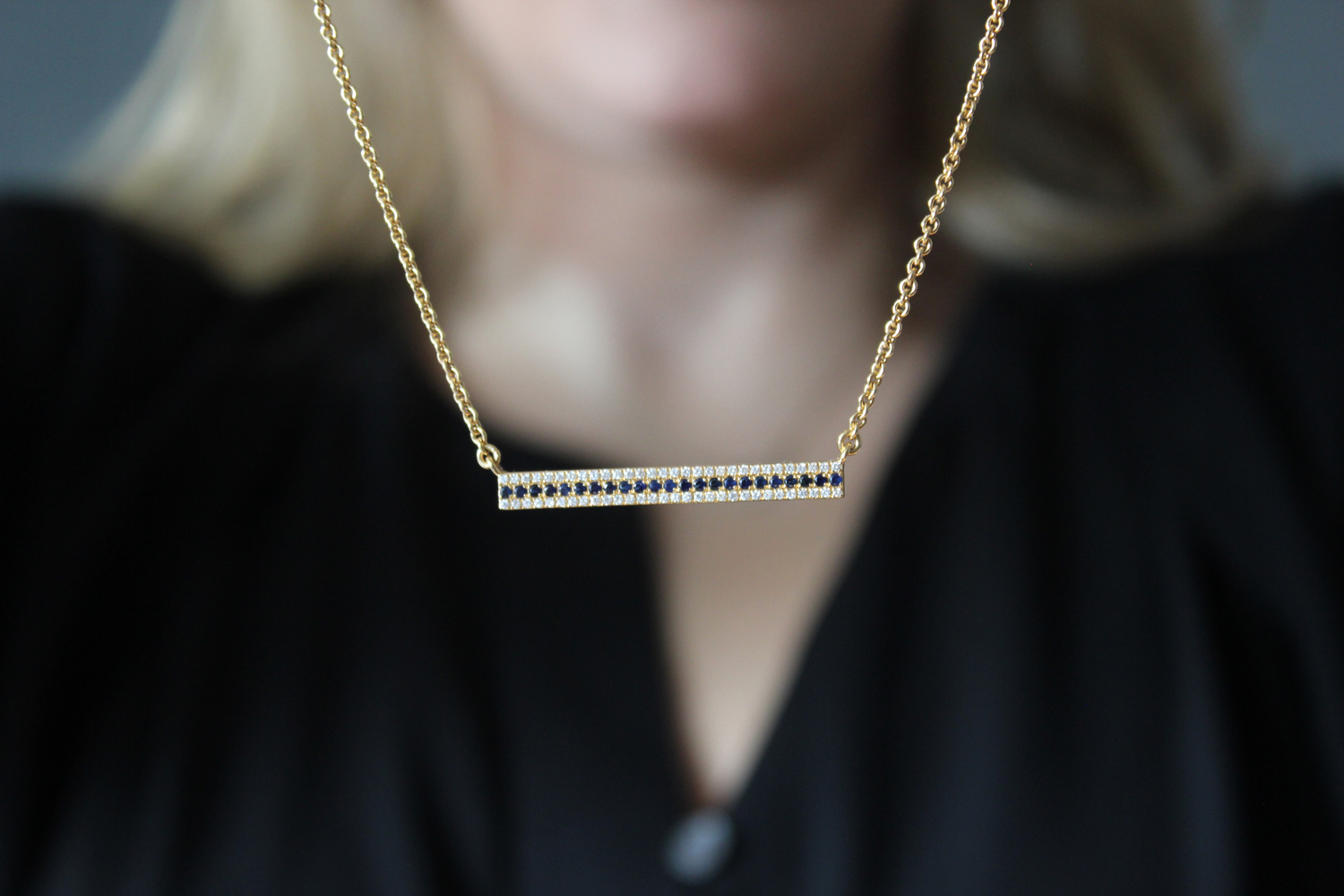 An 18-karat yellow gold diamond and sapphire bar necklace made by Synenberg.