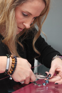 Jamie Synenberg, of Beachwood, sets a 23-stone Swarovski crystal rivoli necklace in her home studio.