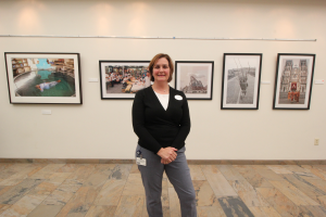 Deborah Bobrow, the Mandel JCC’s arts and culture director, stands in front of photographer Scott Sill’s exhibition, “When You Travel You Are Never Lost,” which showcased images from Sill’s journeys through Asia and was on view in the JCC’s hallways from July 11 to Sept. 5. Photo / Michael C. Butz